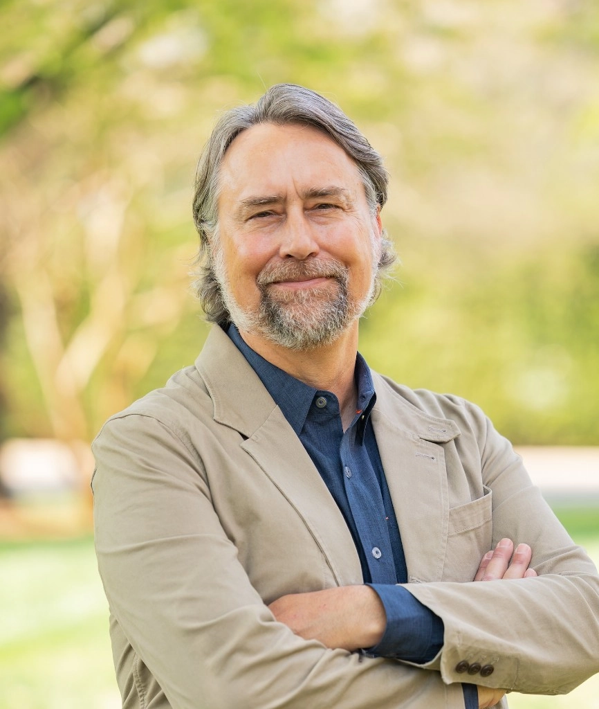 Michael J. Kruger standing outdoors with arms crossed